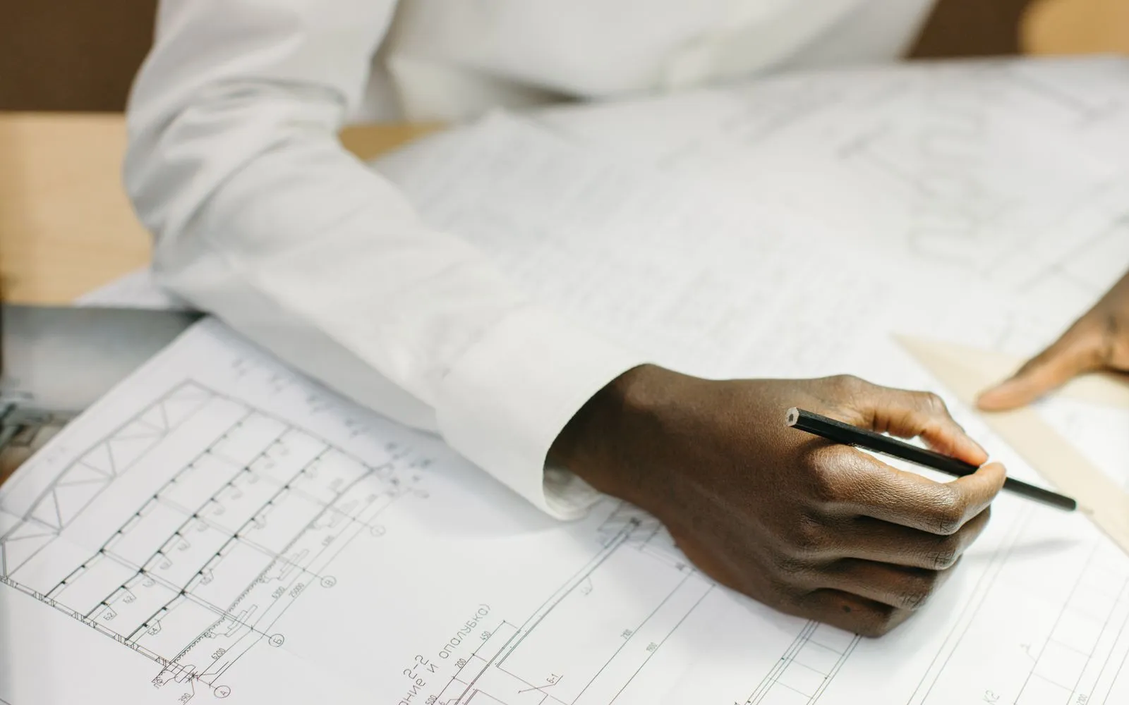 Measuring a printed construction plan by hand with a pencil